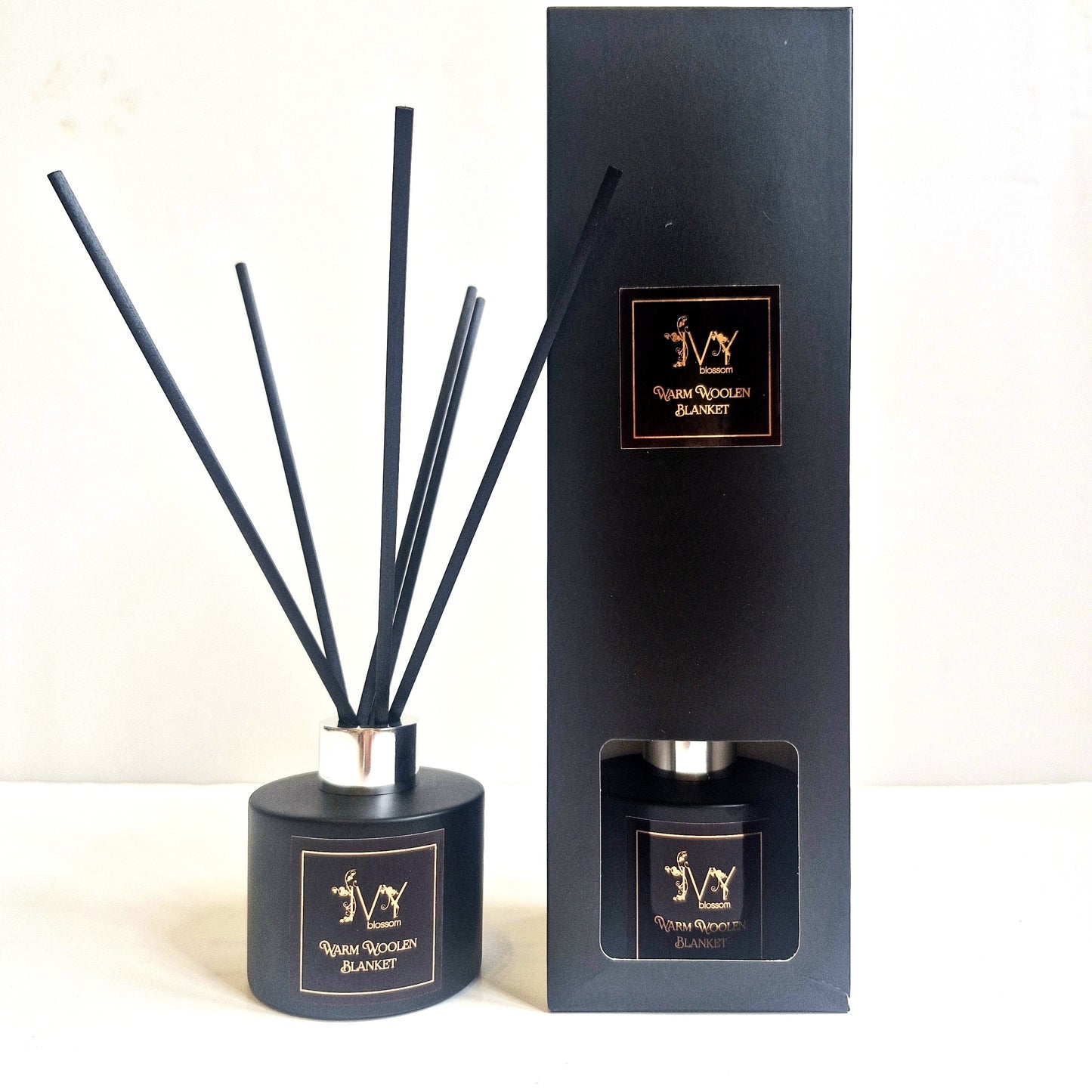 Black diffuser set with reeds and packaging on a white background