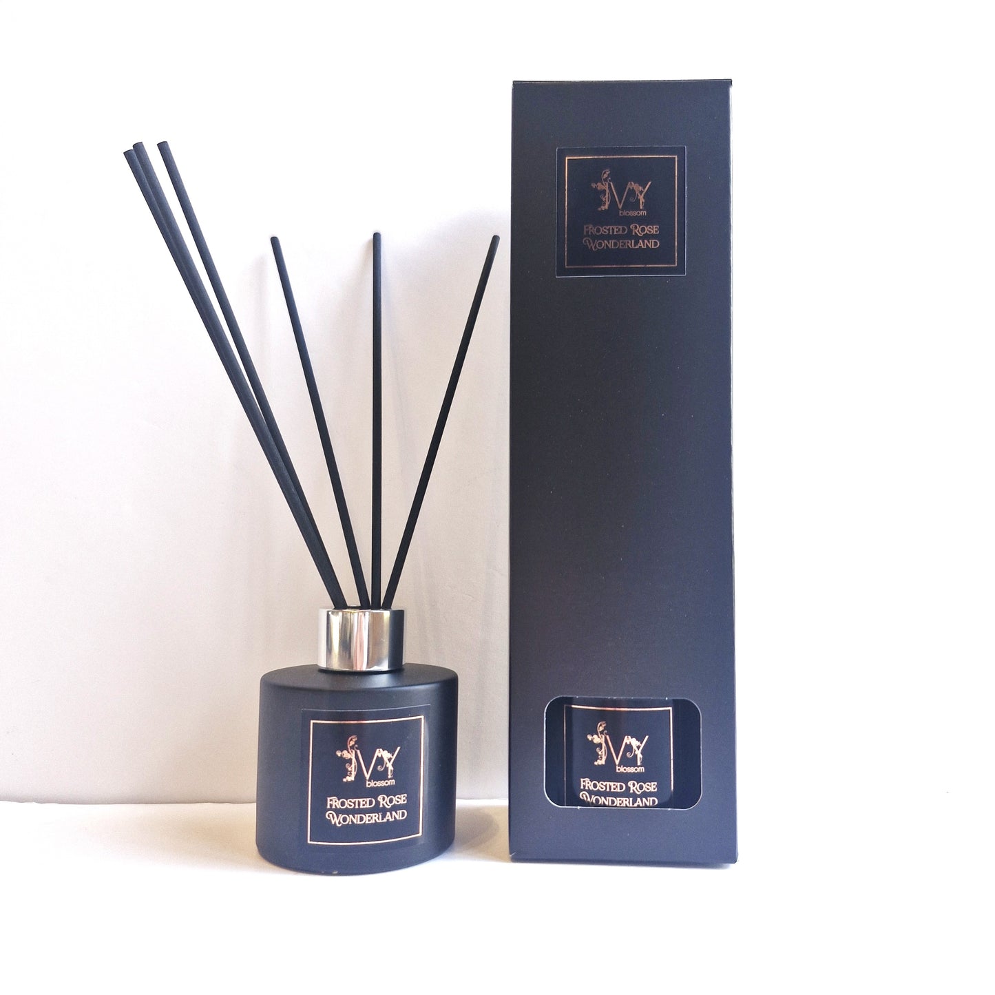 Frosted Rose Wonderland Reed Diffuser with black reeds in stylish packaging.