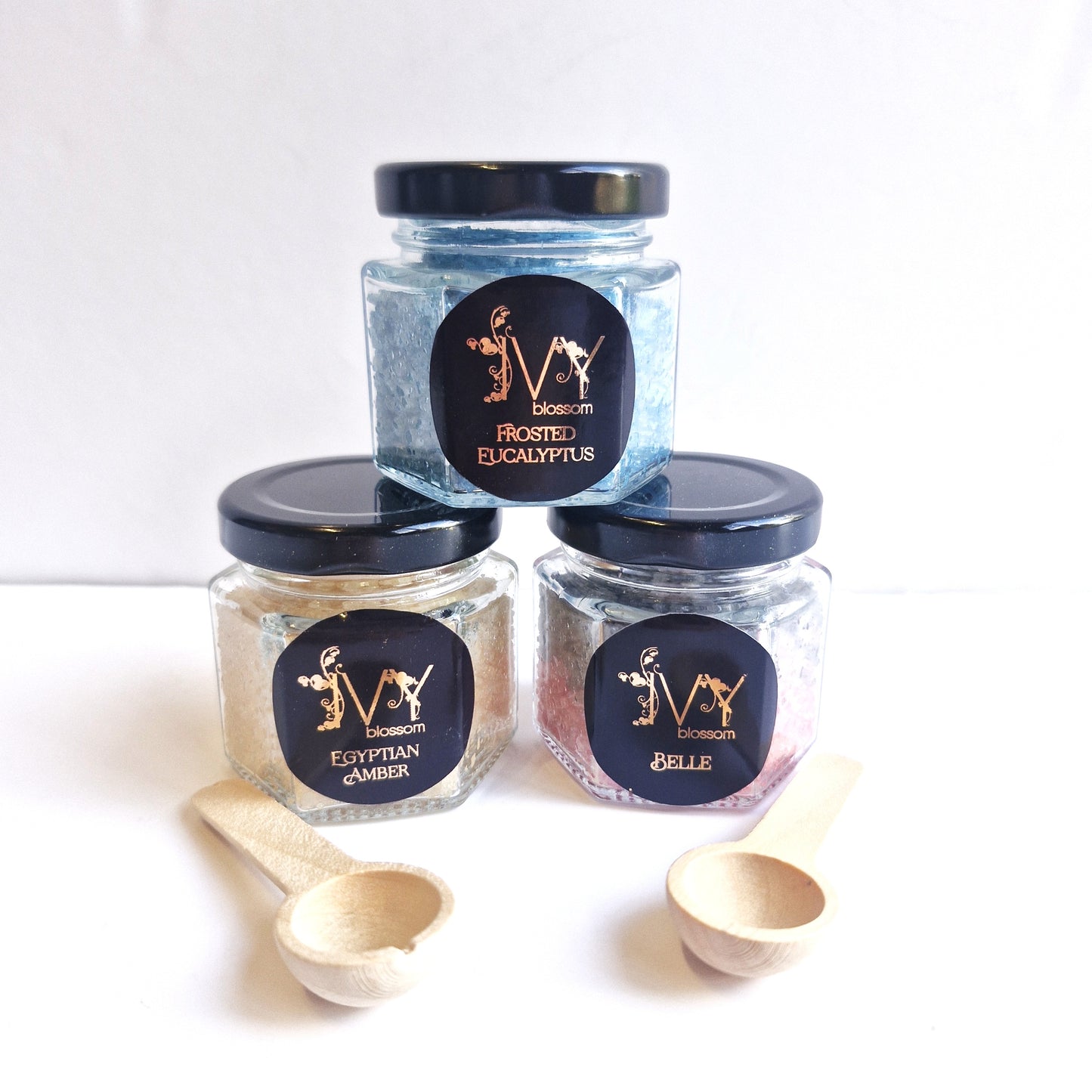 Scented Sizzlers in jars: Frosted Eucalyptus, Egyptian Amber, and Belle with wooden scoops.